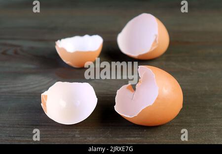 Closeup cracked eggshells isolated on dark brown wooden background Stock Photo