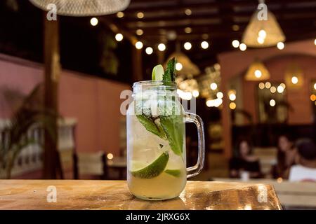 Mint cocktail on a bar in a restaurant with yellow lights. Nightlife Stock Photo