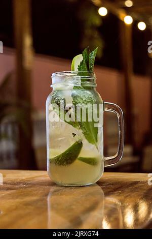 Mint cocktail on a bar in a restaurant with yellow lights. Nightlife Stock Photo