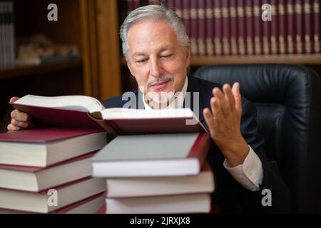 Business man reading a lot of books in his studio Stock Photo