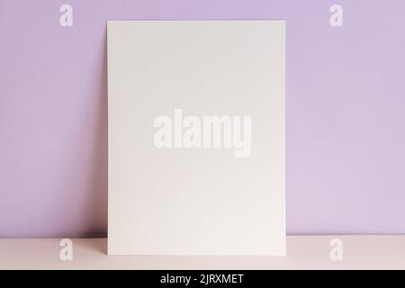 Blank card or poster mock-up over pastel purple wall, template with place for text Stock Photo