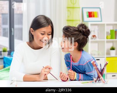 happy mother and daughter drawing at home Stock Photo