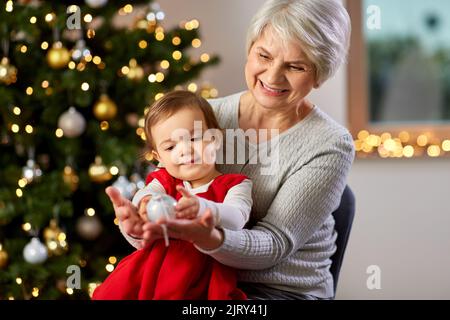grandmother and baby girl with at christmas tree Stock Photo