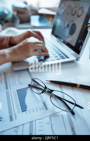 Businessman checking reported profits on the paper and laptop. Stock Photo