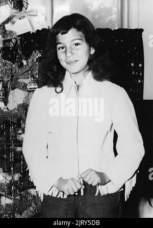 1956 , december , USA : The celebrated american Pop singer and actress  CHER ( Cherilyn Sarkisian LaPierre , born 20 may 1946 ) when was a young girl aged 10 at Xmas  . Unknown photographer. - HISTORY - FOTO STORICHE - personalità da giovane giovani - ragazza - personality personalities when was young girl - INFANZIA - CHILDHOOD - POP MUSIC - MUSICA - cantante - BAMBINI - BAMBINA - CHILD - CHILDREN - BAMBINO - CHILDHOOD - INFANZIA - smile - sorriso - ALBERO DI NATALE - Christmas Tree --- ARCHIVIO GBB Stock Photo