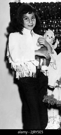 1956 , december , USA : The celebrated american Pop singer and actress  CHER ( Cherilyn Sarkisian LaPierre , born 20 may 1946 ) when was a young girl aged 10 at Xmas  . Unknown photographer. - HISTORY - FOTO STORICHE - personalità da giovane giovani - ragazza - personality personalities when was young girl - INFANZIA - CHILDHOOD - POP MUSIC - MUSICA - cantante - BAMBINI - BAMBINA - CHILD - CHILDREN - BAMBINO - CHILDHOOD - INFANZIA - smile - sorriso - ALBERO DI NATALE - Christmas Tree - doll - bambola - toy - giocattolo - giocattoli - toys --- ARCHIVIO GBB Stock Photo