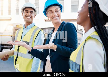 Construction worker, female architect and engineer working as a team on project maintenance on a building site in the city. Teamwork, collaboration Stock Photo
