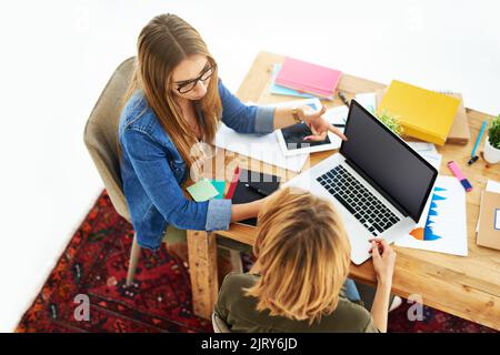 Prepping for exam time together. High angle shot of two female university students working on a project together at a table on campus. Stock Photo