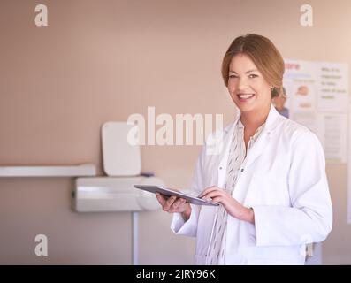 Book yourself a friendly appointment. Portrait of a female dentist using her tablet in her office. Stock Photo