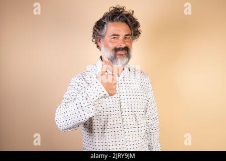 Middle age man with gray hair and beard wearing casual clothes making happy thumbs up gesture with hand. approving expression looking at camera showin Stock Photo