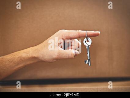 The key to his dream house. an unrecognizable mans hand holding the key to his new home. Stock Photo