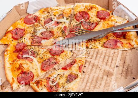 Round pepperoni pizza with fork and knife on it in Rio de Janeiro. Stock Photo