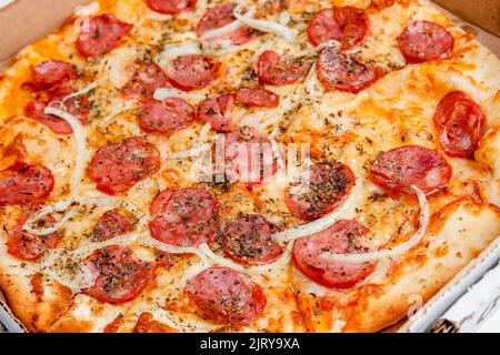 Round pepperoni pizza on a white table in Rio de Janeiro. Stock Photo