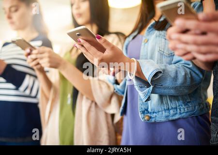 Simultaneous connections. a group of unrecognisable people using their cellphones. Stock Photo