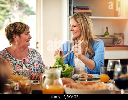 Delicious food made just the way you taught me, Mom. a mature woman and her elderly mother enjoying a meal together at home. Stock Photo
