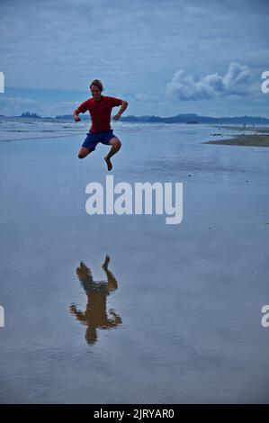 Mature man jumping on the beach and having fun Stock Photo
