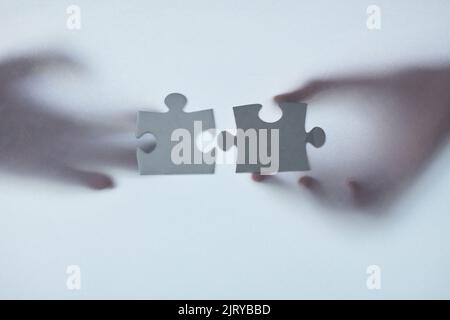 Youll know when you find the perfect fit. Defocussed shot of two unrecognizable businesspeople holding two puzzle pieces together. Stock Photo