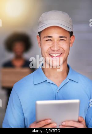 Working down his delivery checklist. Portrait of a happy delivery man making a delivery to a businesswoman in her office. Stock Photo