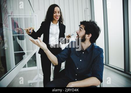 young disabled businessman wearing in wheelchair working and discus with colleague, planning and brainstorming concept Stock Photo