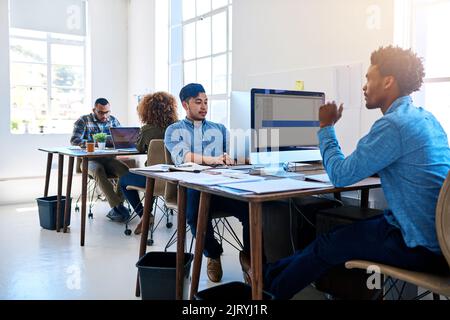 Everyones got a job to do. a team of young professionals at work in a modern office. Stock Photo
