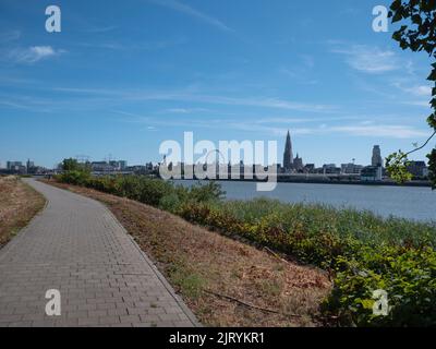 Footpath for pedestrians on the left bank in Antwerp with a view of the river Scheldt and the right bank Stock Photo