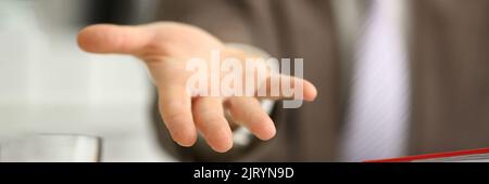 Man in suit extends open hand forward closeup Stock Photo