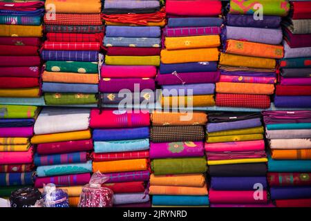 Artistic variety shade tone colors Saree's stacked on retail Shop Shelf to sale Stock Photo