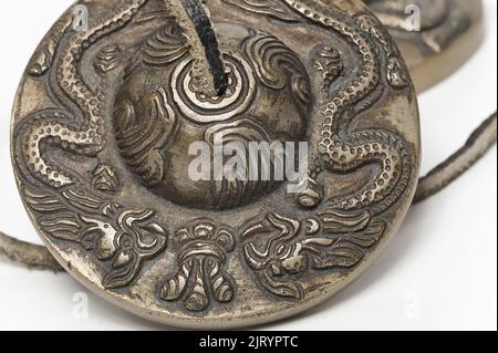 Tibetan Buddhist tingsha cymbal dragons ornament isolated Stock Photo