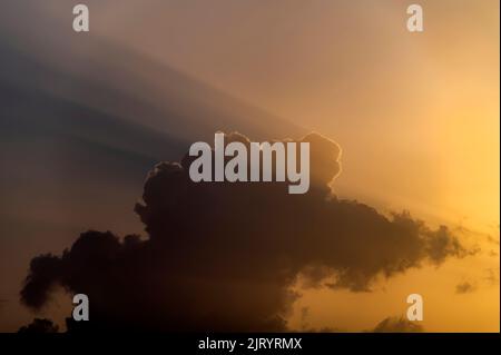 dramatic clouds with light beams, sun rays with clouds in the blue sky Stock Photo