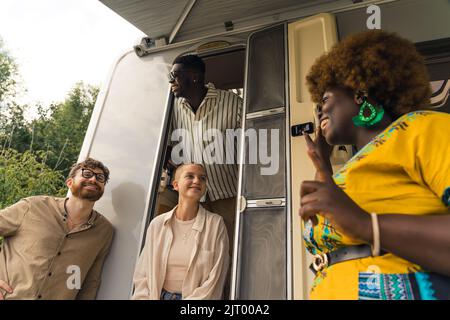 multiethnic friends near the van enjoying on a summer trip. High quality photo Stock Photo