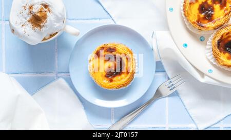 Portuguese dessert Pastel de nata with coffee on blue tile Stock Photo