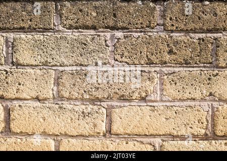 light yellow brick wall background. Horizontal photo of beige rock fence Stock Photo