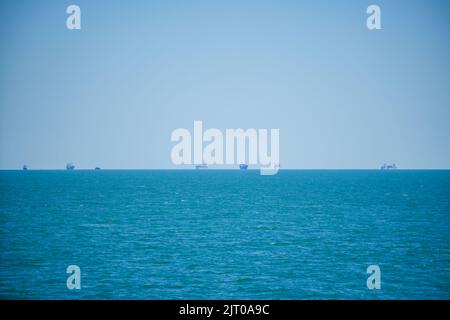 Many enormous, commercial cargo vessels waiting to enter the port. Stock Photo