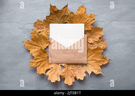 Autumn composition. Craft envelope. card mockup with autumn marple leaves. Flat lay, top view, copy space  Stock Photo