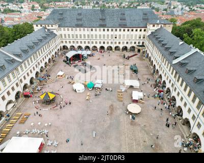 Gotha, Germany. 27th Aug, 2022. Stands of performers stand in the courtyard of the residential palace at the 20th Gotha Baroque Festival. Friedenstein Palace will once again be transformed into the colorful residence of Duke Frederick III of Saxony-Gotha-Altenburg (r. 1732-1772) (photo taken with a drone). Credit: Bodo Schackow/dpa/Alamy Live News Stock Photo