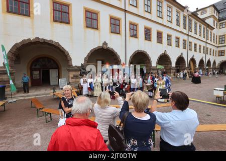 Gotha, Germany. 27th Aug, 2022. Performers in historical costumes are photographed by visitors in the courtyard of the residential palace at the 20th Gotha Baroque Festival. Friedenstein Palace will once again be transformed into the colorful residence of Duke Frederick III of Saxe-Gotha-Altenburg (r. 1732-1772). Credit: Bodo Schackow/dpa/Alamy Live News Stock Photo