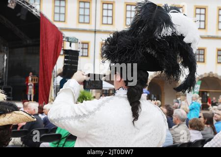 Gotha, Germany. 27th Aug, 2022. A performer in historical costume takes a photo in the courtyard of the residential palace at the 20th Gotha Baroque Festival. Friedenstein Palace will once again be transformed into the colorful residence of Duke Frederick III of Saxe-Gotha-Altenburg (r. 1732-1772). Credit: Bodo Schackow/dpa/Alamy Live News Stock Photo