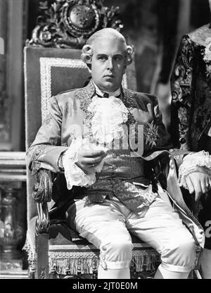 ROBERT MORLEY as King Louis XVI sitting on throne in MARIE ANTOINETTE 1938 director W.S. VAN DYKE art direction Cedric Gibbons gowns by Gilbert Adrian producer Hunt Stromberg Metro Goldwyn Mayer Stock Photo