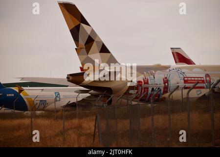 Teruel, Spain-August 25, 2022: Planes painted with London landscape at the aircraft scrapyard on the runway near the metal fence. Stock Photo