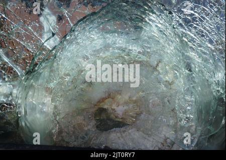 Armored glass after of a direct hit from an automatic weapon. Safety glass after being hit by a bullet. Bulletproof glass armored car after gunshot. T Stock Photo