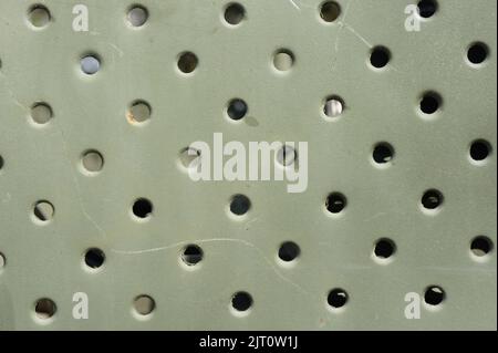 Lattice texture close up. Holes of grey metal plate with round regular holes texture background. Military Texture. Lattice construction on military ve Stock Photo
