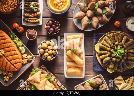 Arabic Cuisine;Middle Eastern traditional dishes and assorted meze. Vine leaves, kibbeh,chicken fatteh, spring rolls, sambusak, kibbeh and makdous. Stock Photo