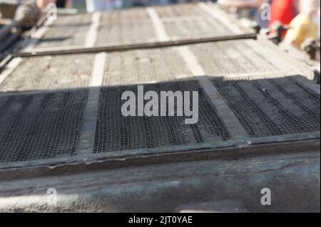 Lattice texture close up. Holes of grey metal plate with round regular holes texture background. Military Texture. Lattice construction on military ve Stock Photo
