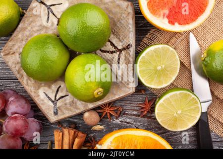 sliced lime on a plate on wood background Stock Photo