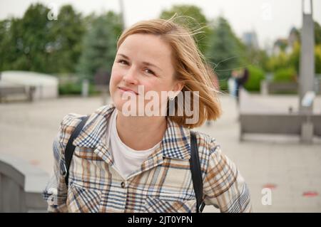 Portrait of attractive white european woman in the city outdoors. Happy smiling beautiful woman. Lifestyle photo. Stock Photo