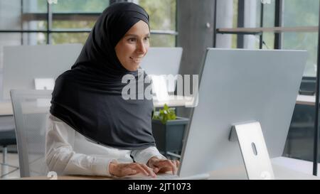 Excited joyful businesswoman sitting at workplace in office receiving email on computer reading excellent news enthusiastic happy woman manager Stock Photo
