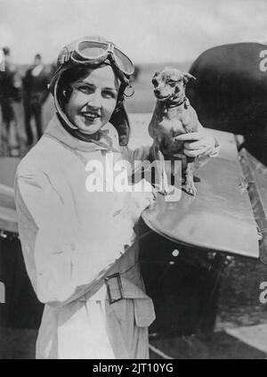 Rosalie Gordon. American pilot in Gates Flying Cirucs that in the 1920s became exceedingly popular and drew around 30 000 spectators to every show. She was one of the Gates Flying Circus main attractions as the first female skydiver. Pictured here beside her airplane with her dog. 1930s. Stock Photo