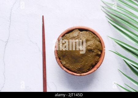 The wooden bowl with rehydrated henna on table Stock Photo