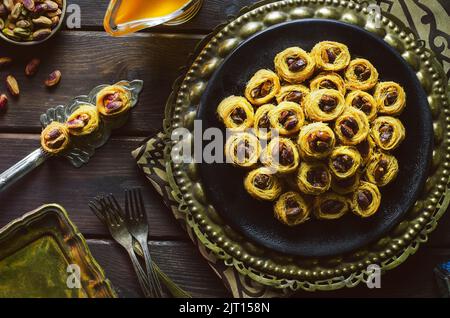 Arabic cuisine; Middle Eastern traditional pastries and Ramadan famous dessert 'Kunafa' with roasted pistachio. Stock Photo