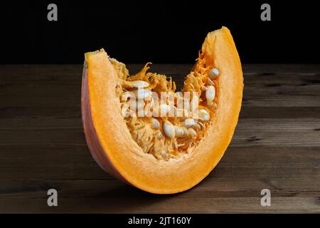 Fresh organic pumpkin slice with seeds on a dark background Stock Photo